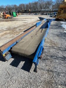 MachineX 32 foot sliderbed conveyor in a yard, view down the belt