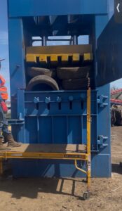 Blue high density vertical tire baler with tires in the chamber