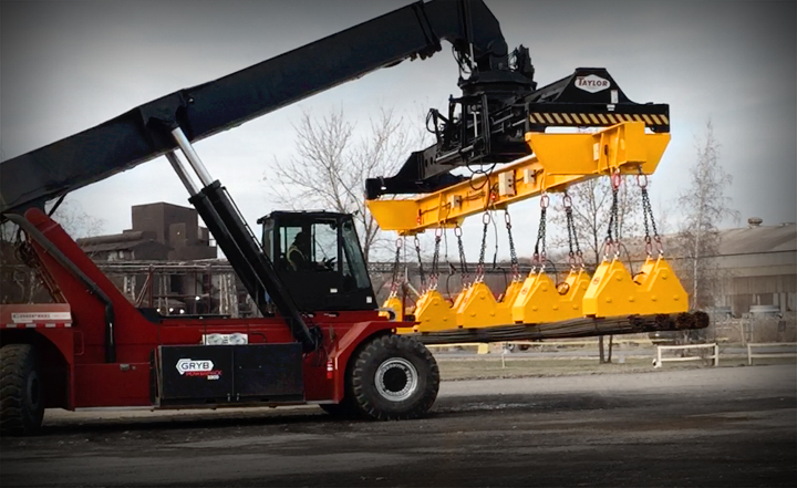 Reach stacker carrying steel plate with lifting magnets
