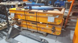 Orange Eriez cross belt magnet stacked on a pallet