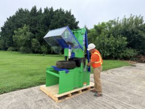 Operator loading a tire into a Green Car Depollution wheel rim popper