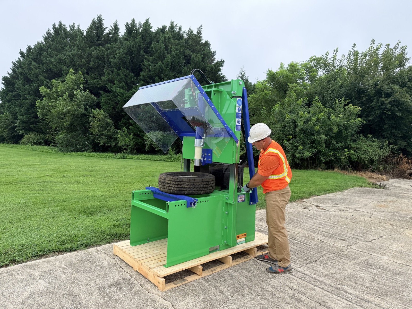 Operator loading a tire into a Green Car Depollution wheel rim popper